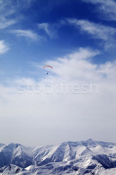 Sunlight mountain with clouds and silhouette of paraglider Stock photo © BSANI