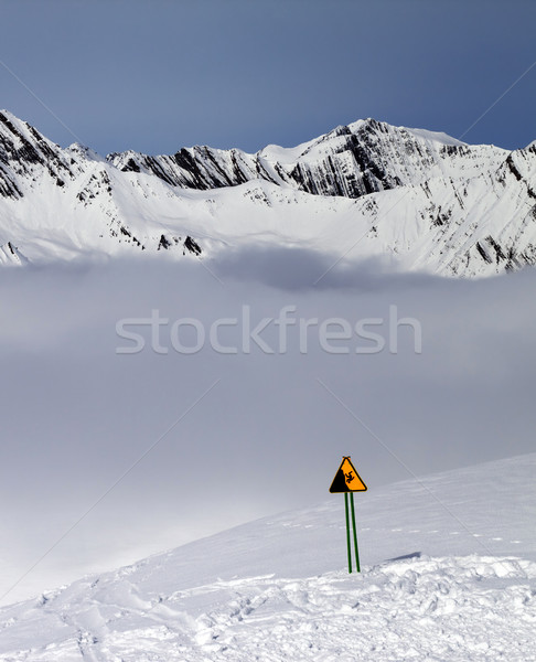 Warning sing on ski slope and mountains in fog Stock photo © BSANI