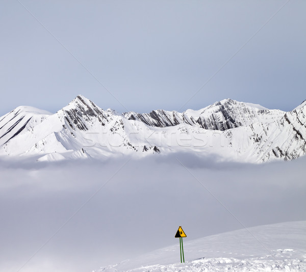 Mountains in mist and warning sing on ski slope Stock photo © BSANI