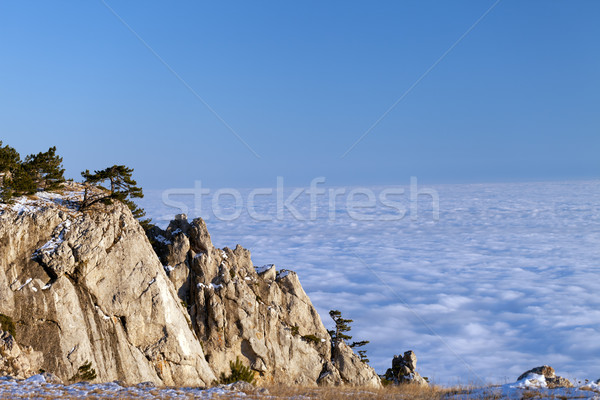 Stock photo: Sunlit cliffs and sea in clouds