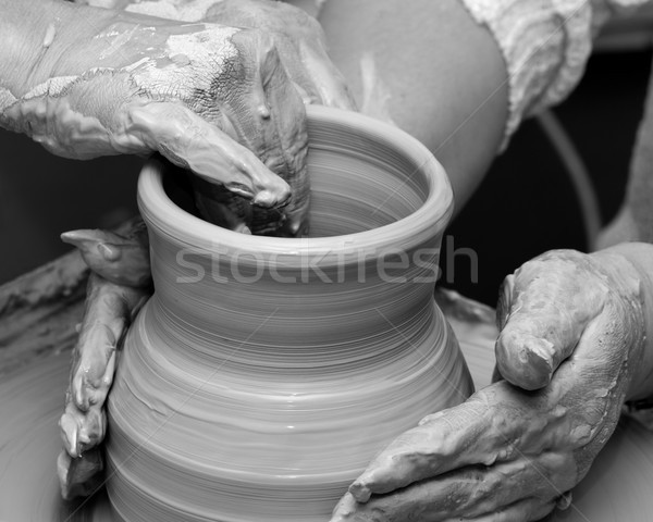 Two women in process of making clay vase on pottery wheel Stock photo © BSANI