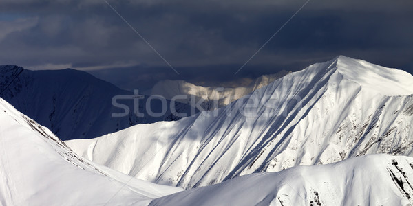 Panoramic view on snowy sunlit mountains and overcast sky Stock photo © BSANI