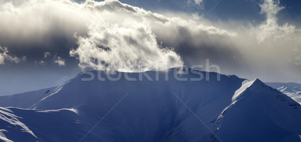 Panoramic view of mountains in sunset with sunlit clouds Stock photo © BSANI