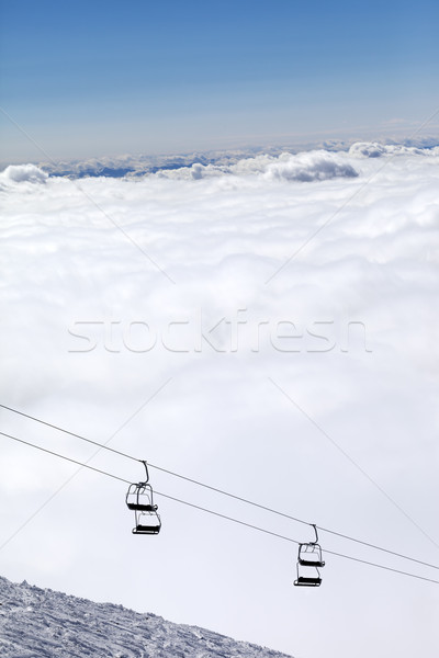 Stock photo: Ski slope, chair-lift and mountains under clouds
