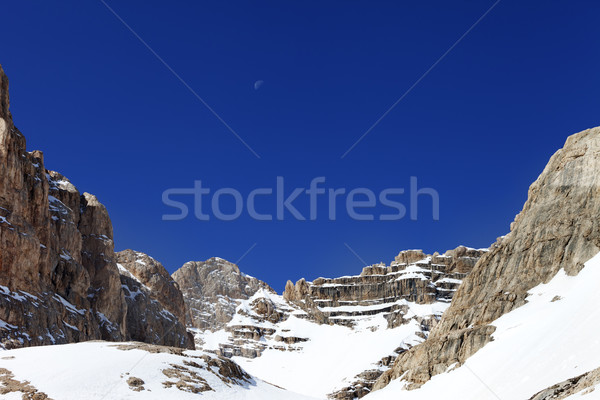 Snowy rocks and cloudless blue sky with moon Stock photo © BSANI