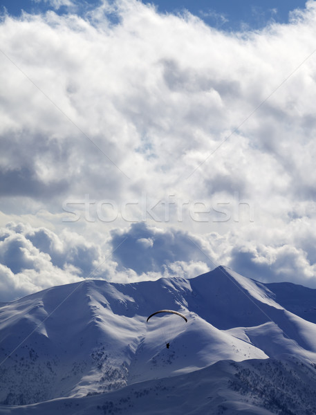Evening sunlight mountain and silhouette of paraglider Stock photo © BSANI
