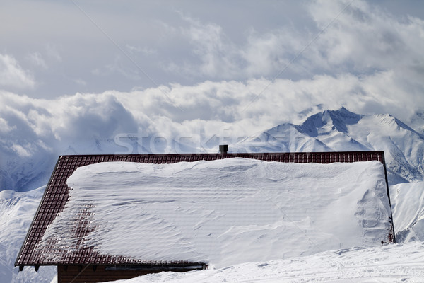 Snowy roof and mountains in clouds Stock photo © BSANI