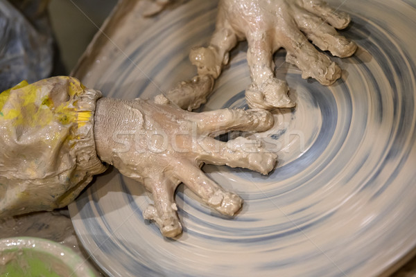 Hands of young girl in clay on pottery wheel Stock photo © BSANI