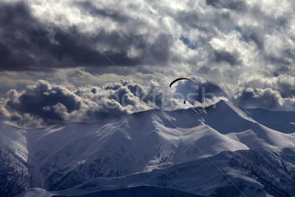 Evening mountain with clouds and silhouette of parachutist Stock photo © BSANI