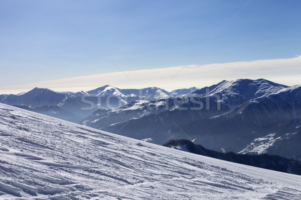 Ski slope with trace of ski, snowboards and mountains in haze Stock photo © BSANI