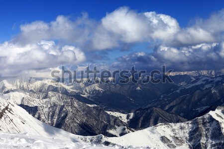 Sunlit winter mountains in clouds, view from off-piste slope Stock photo © BSANI