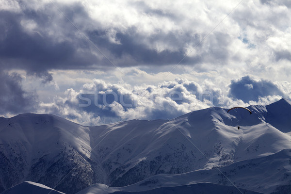 Evening sunlight mountain and silhouette of parachutist Stock photo © BSANI