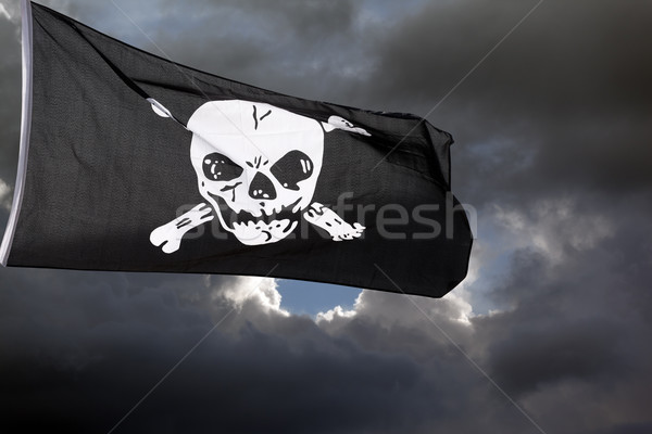 Jolly Roger (pirate flag) against storm clouds Stock photo © BSANI