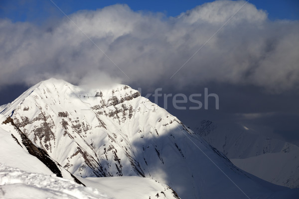 Snowy sunlit mountains and blue sky with clouds Stock photo © BSANI