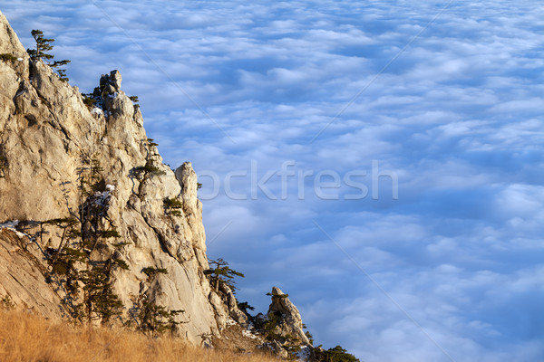 Sunlit cliffs and sea in clouds Stock photo © BSANI