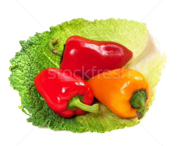 Red and yellow sweet peppers on leaf of savoy cabbage Stock photo © BSANI