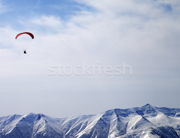 Paraglider silhouette of mountains in sunlight sky Stock photo © BSANI