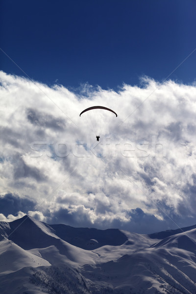 Winter mountains with clouds and silhouette of parachutist Stock photo © BSANI