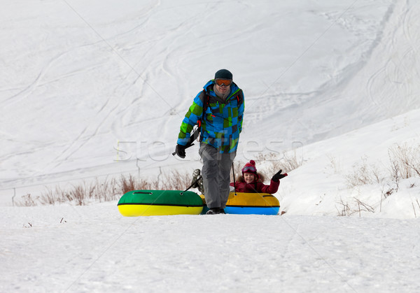 Stock photo: Father and daughter with snow tube