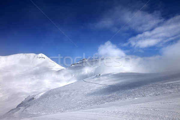 Ski slope with snowmobile trail and mountains in mist at nice da Stock photo © BSANI