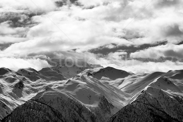 Stock photo: Black and white view on snowy mountains and cloudy sky at evenin
