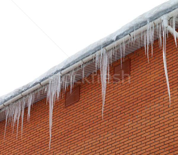 Snow-covered roof with icicles on white background Stock photo © BSANI