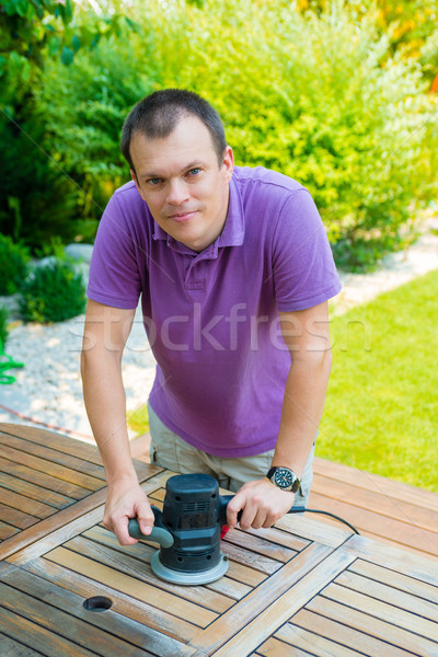 Close-up of old carpenter's hands working with electric sander Stock photo © bubutu