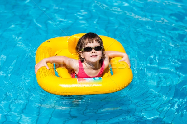 Cute girl swims in a pool in a yellow life preserver  Stock photo © bubutu