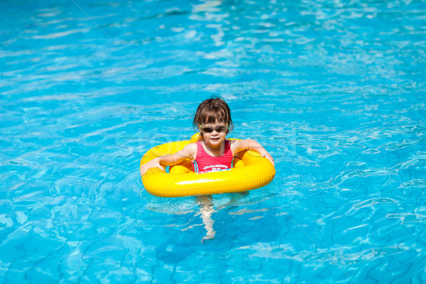 Cute girl swims in a pool in a yellow life preserver  Stock photo © bubutu