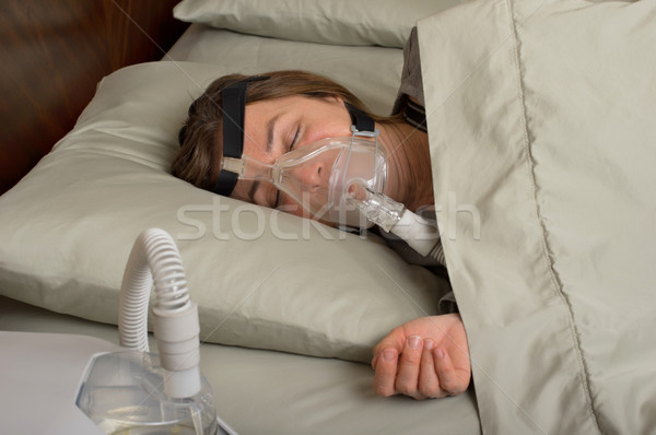 Schlaf Frau tragen Maschine Maske Schlafzimmer Stock foto © BVDC
