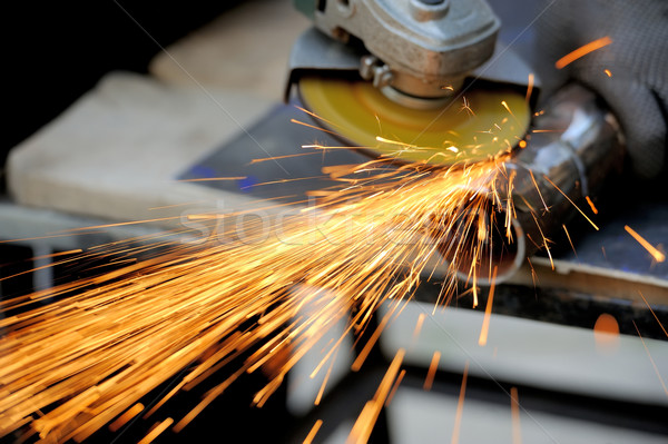 Worker cutting metal with grinder Stock photo © byrdyak