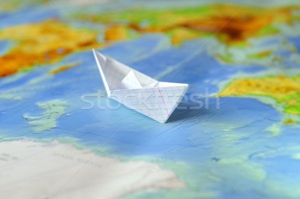 Paper boat on a background map of the world Stock photo © byrdyak