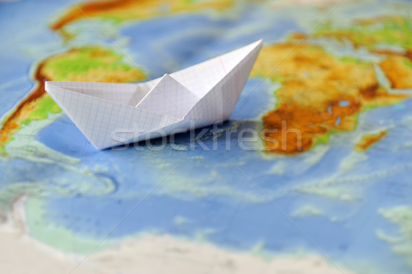 Paper boat on a background map of the world Stock photo © byrdyak