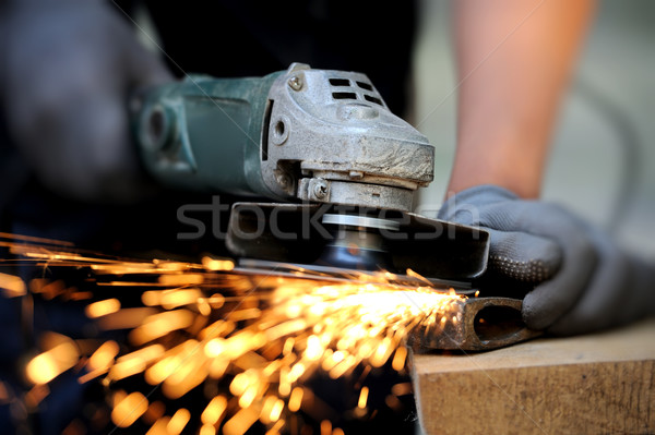Worker cutting metal with grinder Stock photo © byrdyak