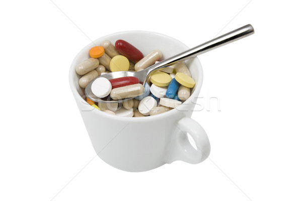 cup of multicolored tablets and capsules with spoon Stock photo © caimacanul