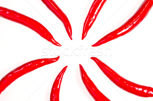 Red chilies peppers pointing towards the center circle Stock photo © calvste