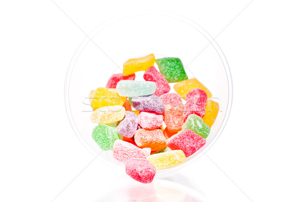 Colourful fruit jelly candies falling out of a bowl on white background Stock photo © calvste