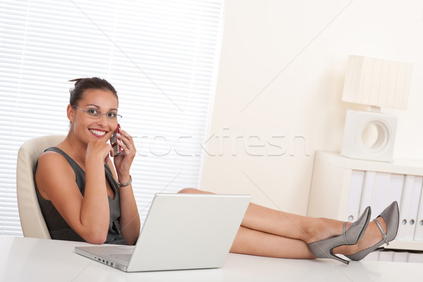 Stock photo: Female manager working with legs up