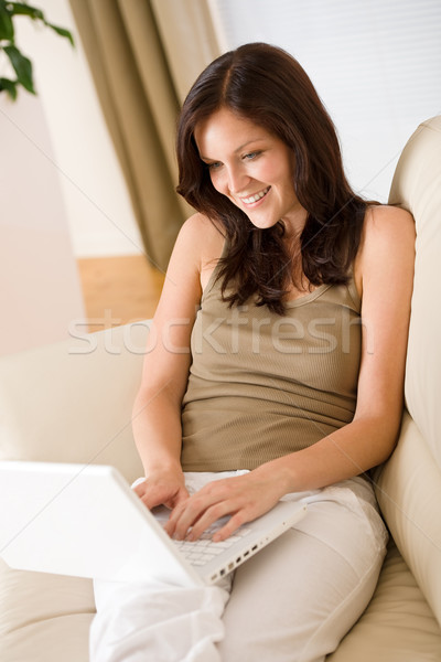 Mosolygó nő laptop kanapé társalgó ül nő Stock fotó © CandyboxPhoto