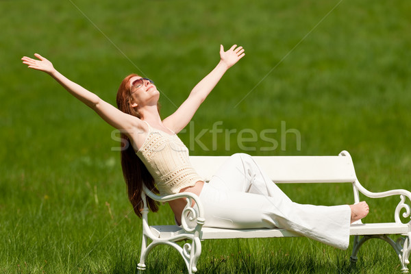 Stock photo: Red hair woman enjoying sun on white bench in spring