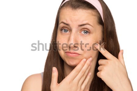 Unhappy girl squeezing pimple on cheek isolated Stock photo © CandyboxPhoto