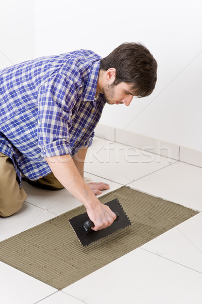 Stock photo: Home improvement - handyman laying tile