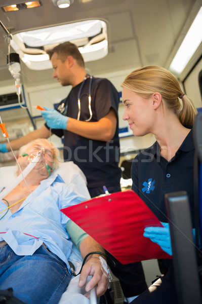 Paramedics examining injured patient in ambulance Stock photo © CandyboxPhoto