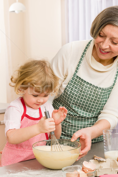 Grandmother and granddaughter whisk dough Stock photo © CandyboxPhoto