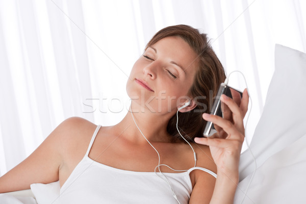 商業照片: 年輕女子 · 聽音樂 · mp3播放器 · 白 · 沙發
