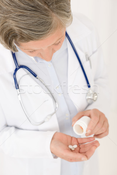 Foto stock: Altos · médico · femenino · mantener · pastillas · mirando · hacia · abajo