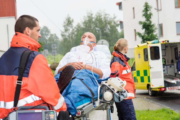 Stock photo: Paramedics with patient on stretcher ambulance aid