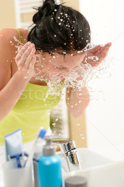 Woman splashing water on face in bathroom Stock photo © CandyboxPhoto