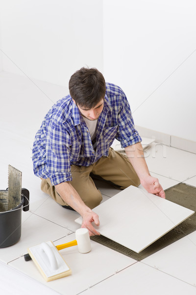 Stock photo: Home improvement - handyman laying tile
