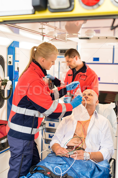 Stock photo: Paramedic putting oxygen mask on patient ambulance